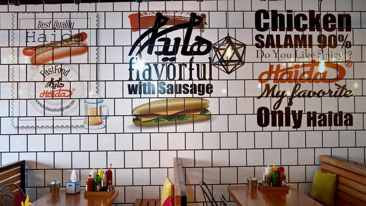Restaurant wall branding with food graphics on tile surface by InnoPrint KSA