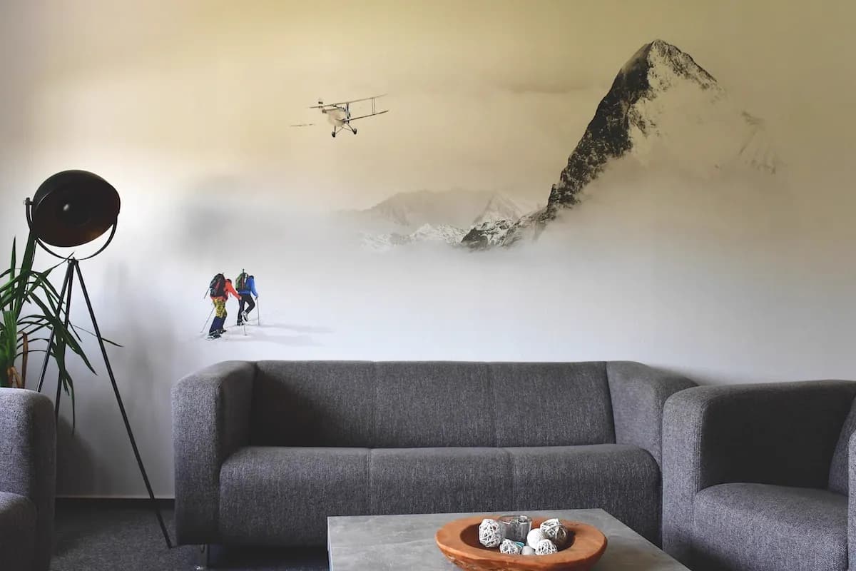 Living room wall mural with alpine mountain climbers and vintage airplane by InnoPrint KSA